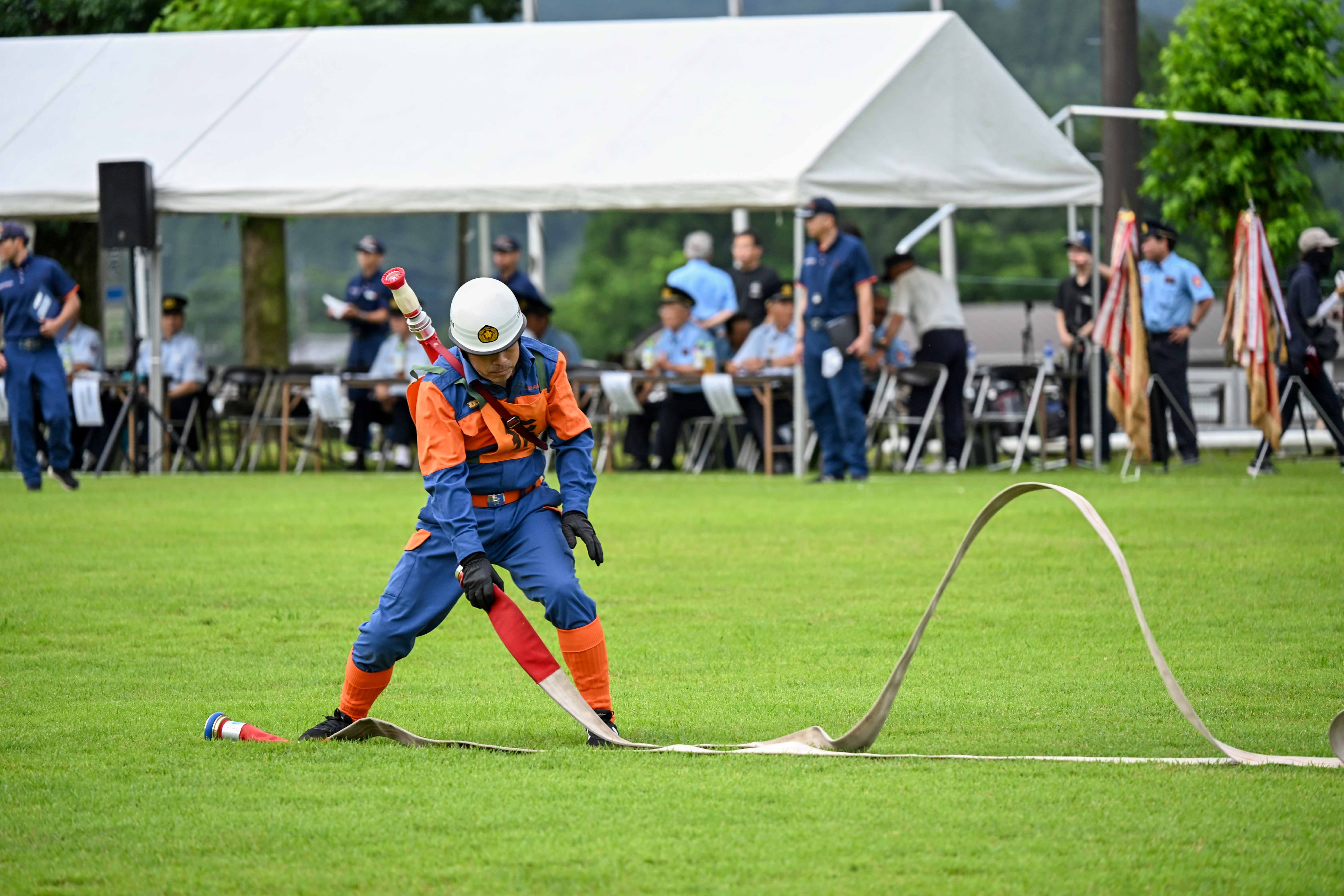 ホースを伸ばす消防団員の正面姿