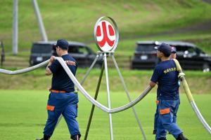 ホースを担ぐ２人の消防団員